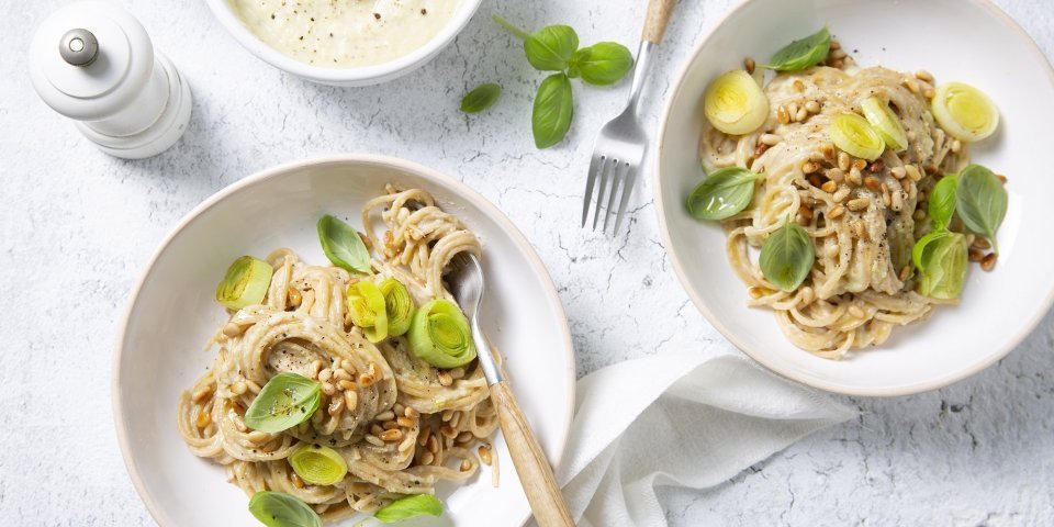 Pasta met gezonde witte saus en prei Twee porties pastas komen eraan! Wel met een gezonde bechamelsaus deze keer, eentje op basis van bloemkool. We doen er nog een extra portie prei bovenop en werken af met basilicumblaadjes voor de smaak en mooie groene kleur.