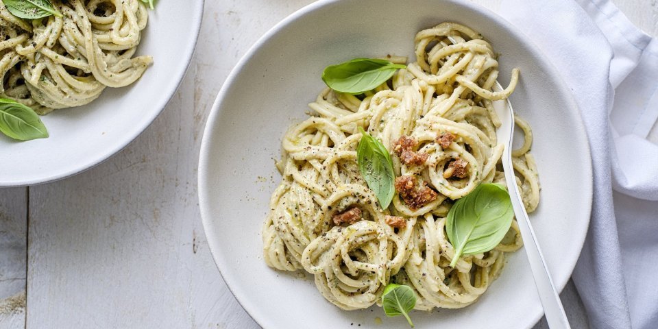 Pesto van aubergine en Belgische ricotta met pasta In een bord zit de spaghetti met een pesto gemaakt van aubergine en ricotta. We werken het gerechtje af met nog wat mooie blaadjes basilicum en krokantje broodkruimels.