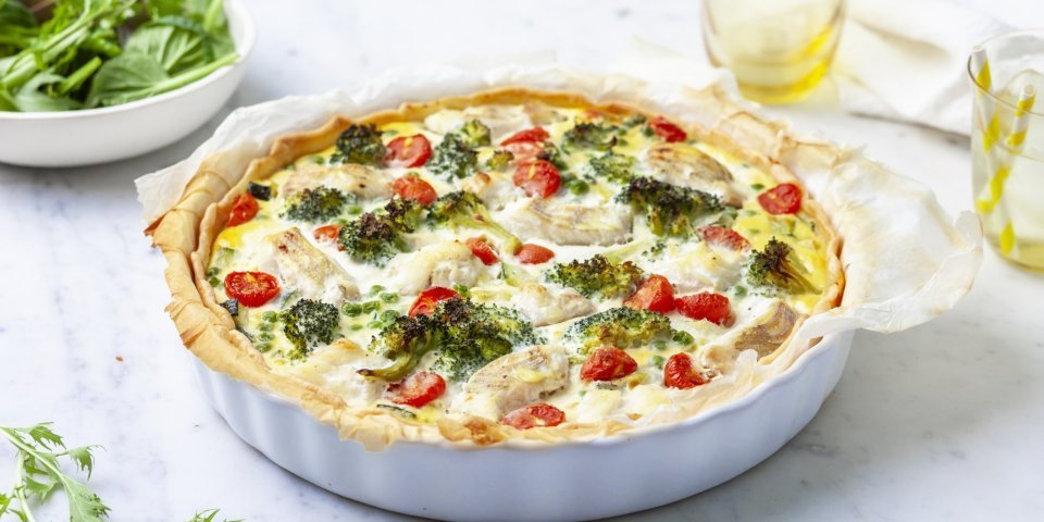 Quiche met schelvis en broccoli Het lijkt alsof de quiche net uit de oven komt. Ze staat nog ongesneden op het aanrecht klaar om aan te snijden en te smullen van deze hartige taart met broccoli, tomaatjes en schelvis.