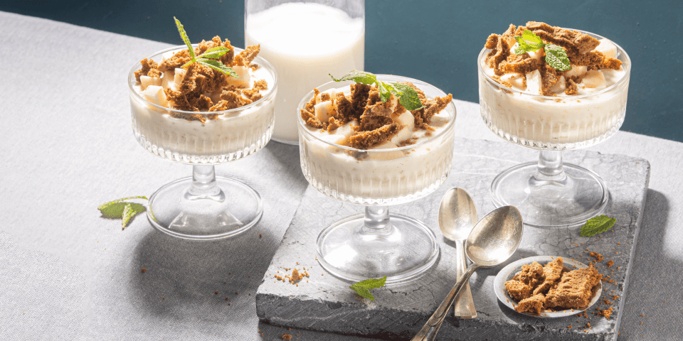 Rijstpap met appel en bastognekoekjes Rijstpap geserveerd in mooie champagnecoupes zorgen instant voor een dessert met sterallures. Hij kreeg een topping mee van appelblokjes en bastognekoekjes voor een crunch. Er zijn 3 glaasjes in beeld.