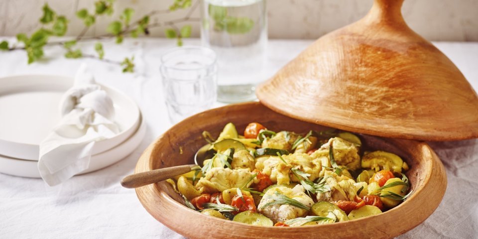 Op de tafel staat de klaargemaakte tajine boordevol lekkers van bij ons. We maakten hem met vis, zeeduivel, krieltjes, tomaatjes en courgette dit samen met kruiden tot een heerlijk hoofdmaal. 