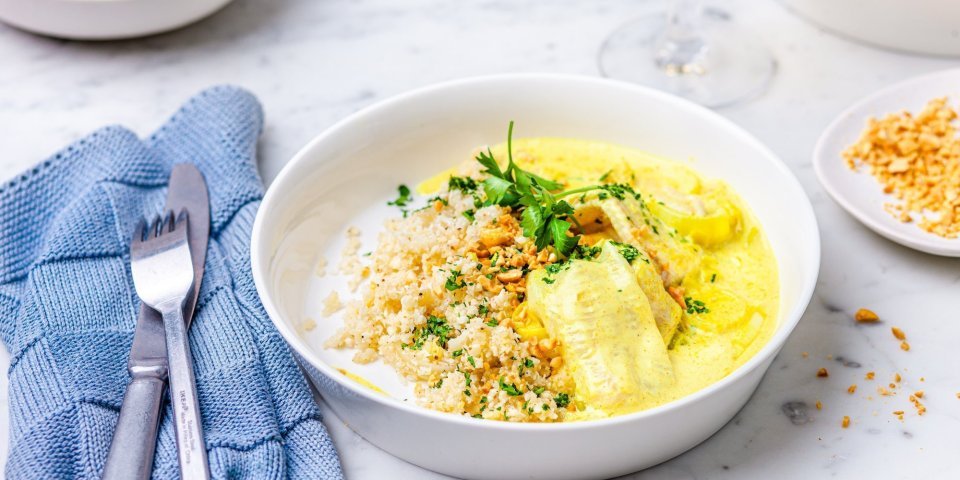 Dit gerechtje is er eentje om je broodje in te doppen, tongschar in currysaus met bloemkoolrijst. Er ligt een blauwe servette langs en een glaasje witte wijn. 