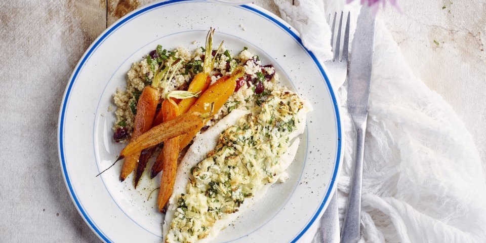 Tongschar met een crumble van hangop en groene kruiden uit de airfryer De krokante tongschar vanuit de airfryer ligt op een wit bord met blauwe randje. De vis werd opgediend met couscous en geroosterde wortelen.