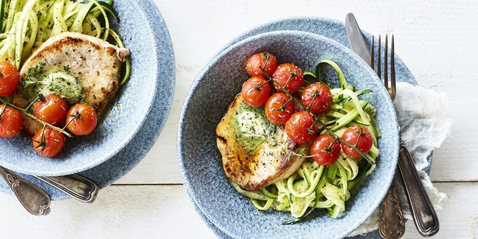 Varkensfilet met gewokte courgetti, kerstomaatjes en kruidenolie Een heerlijke stukje varkensfilet ligt op een bedje van courgetti. We dienen het gerechtje op met kruidenolie en ovengeroosterde kerstomaatjes. Het gerechtje is gepresenteerd in trendy blauw diep bordje.