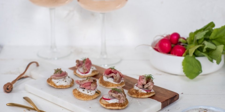 Aardappelblini's met biefstuk, radijsjes en kruidige yoghurtsaus Aardappelblini's met biefstuk, radijsjes en kruidige yoghurtsaus