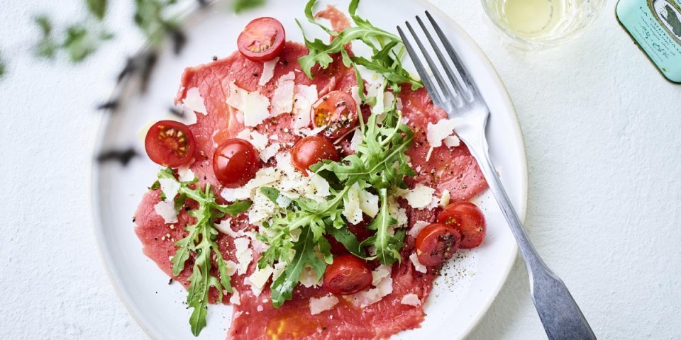 Carpaccio de bœuf aux tomates cerises, roquette et parmesan Carpaccio de bœuf aux tomates cerises, roquette et parmesan
