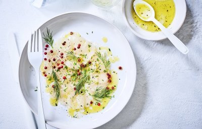 Carpaccio van sint-jakobsnoten met een vinaigrette van olijfolie, citroensap, bieslook en dille. Afgewerkt met rode peperbolletjes, een fris, snel en simpel voorgerecht met groots resultaat.