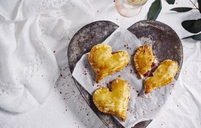 Empanadas gemaakt in hartjesvorm liggen op een bordje te schitteren. Met dit hapje scoor je sowieso bij je geliefde. 