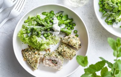 Hier wil ik meteen aan beginnen. De kipfilet is gevuld met basilicum, plakje kaas en ham. Daarna kreeg hij een flinke laag pako over zich heen en ging hij de oven in. Wij combineren deze krokante gegrilde kipfilet met een groene salade op basis van krulsla, erwtjes, groene asperges en verse munt. Dit gerechtje is opgediend in een wit bord om de groene kleur extra pit te geven. 