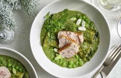 In een diep bord liggen 2 gevulde canneloni, ze liggen in een groen-romig sausje met verse kruiden. Hierbovenop liggen verse kruiden, erwtjes en stukjes kalfsvlees. Een feestelijk en eenvoudig feestgerecht waarbij ieders bord uitlikt. 