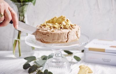 Een heerlijke no-bake taart die niemand koud laat. De cheesecake staat op een hoge taartenschaal en wordt aangesneden. De kaastaart is er eentje met chocolade, Antwerpse handjes en Maltesers. Heerlijk lekker met andere woorden. 