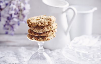 Heerlijke homemade cookies. Wij maakte er met appeltjes en pindakaas, een topcominatie. Ze liggen op de voet van een omgedraaid wijnglas. Achteraan de foto vind je een bloem van een Blauwe regen, melkkan en koffiekan. 