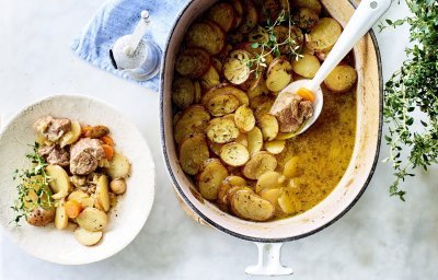 Stoofpotje met lamsvlees staat klaar op tafel om uit geschept te worden. Bovenop de stoofpot ligt een laagje krokante aardappelschijfjes. Deze stoofpot noemt men Lancashire hotpot. 