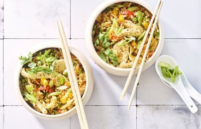 Twee kommetjes staan op het aanrecht. Wij maakten een op-en-top Belgische variant op de Nasi goreng, nl eentje met bloemkoolrijst, paprika, erwtjes en kip van bij ons. 