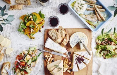 De tafel staat klaar om aan te vallen. Er staat een kaasplank op met Belgische kazen en verschillende bijgerechten met fruit en groenten. Wijn en brood mogen natuurlijk niet ontbreken bij deze pittige kazen.