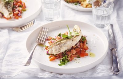 Een rond bordje staat op tafel. De kleurrijke tomatensalsa springt in het oog, hierop ligt een stukje vis. Rode poon, lekker van bij ons.  