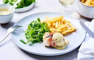 Een licht blauw bord staat op tafel, gevuld met frietjes, veldsla-slaatje en een saltimbocca van vis. Wij serveren hem met huisgemaakte bearnaisesaus. Een feestgerechtje dus. 