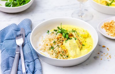 Dit gerechtje is er eentje om je broodje in te doppen, tongschar in currysaus met bloemkoolrijst. Er ligt een blauwe servette langs en een glaasje witte wijn. 