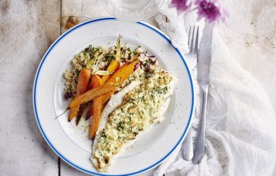 De krokante tongschar vanuit de airfryer ligt op een wit bord met blauwe randje. De vis werd opgediend met couscous en geroosterde wortelen. 