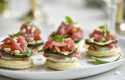 Feestelijke hapjes die de show stelen! Deze torentjes van kruimeldeeg, carpaccio en Belgische ricotta is een schot in de roos voor tijdens de feestdagen. Onderaan ligt een koekje van kruimeldeeg, hierop de ricotta met basilicum, rundvlees, gegrilde courgette en opnieuw rundvlees. Afwerken deden we met pijnboompitten en een extra blaadje basilicum.