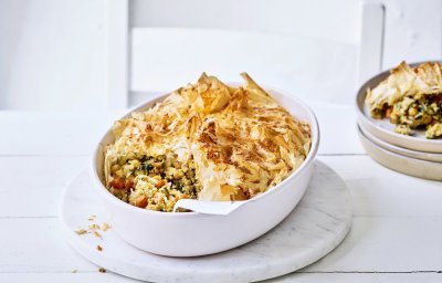 Pastilla is een hartige pastei met een zoete touch. Pastilla maak je met filodeeg, de traditionele is met kip maar wij maakte een vegetarische versie. Hier is hij opgediend in een grote witte ovenschotel waaruit al 1 portie is uitgeschept en naast de schotel staat.   