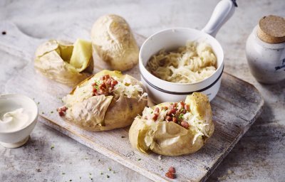 Gepofte aardappel gevuld met zuurkool en stukjes rookworst