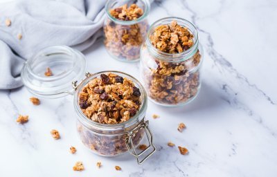 Homemade granola in 2 bokalen op het marmere aanrecht. 