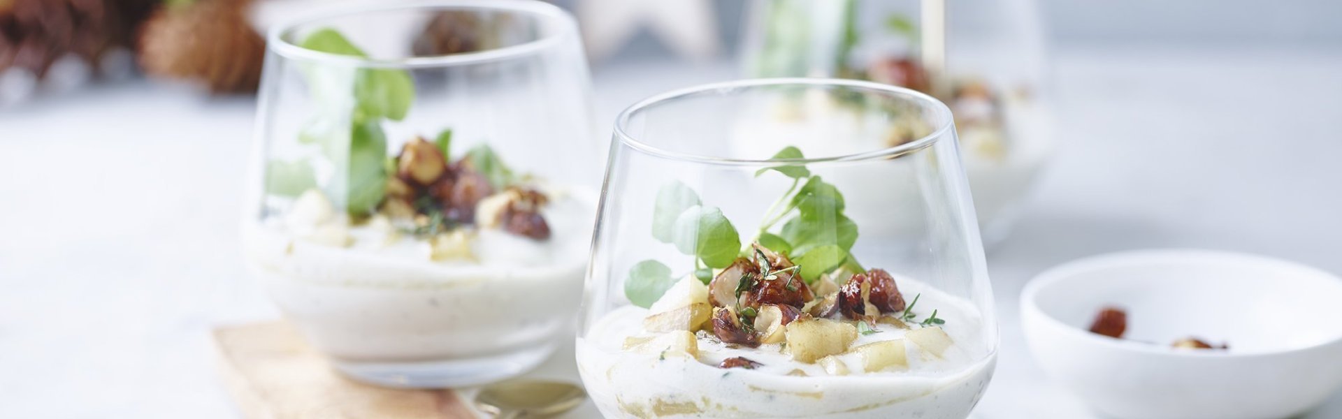 Feestelijk hapje in een glaasje. Het is een blauwe kaasmousse met gebakken peer en notencrunch, ideaal om je feestmenu in te zetten.