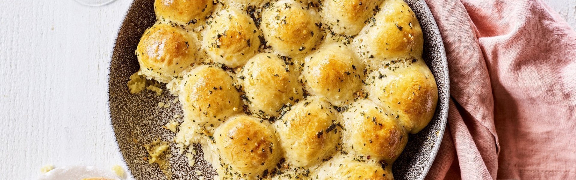 In het midden van de tafel vind je een groot rond keramiek bord in aardekleur. Hierin liggen de goudgele briochebroodjes met knoflookboter, en gevuld zijn met abdijkaas. Instant feestlook en heerlijk smaakvol als bijgerecht.  