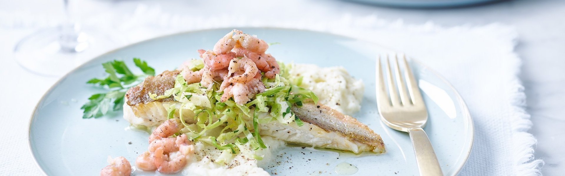 Gebakken rode poon met garnaaltjes, bloemkoolpuree en spruitjessalade Gebakken rode poon op een licht blauw bord, afgewerkt met verse Noordzeegarnalen en spruitjessalade. Hij wordt klaargemaakt met een bloemkoolpuree, een echte voltreffer qua smaken dit bordje.