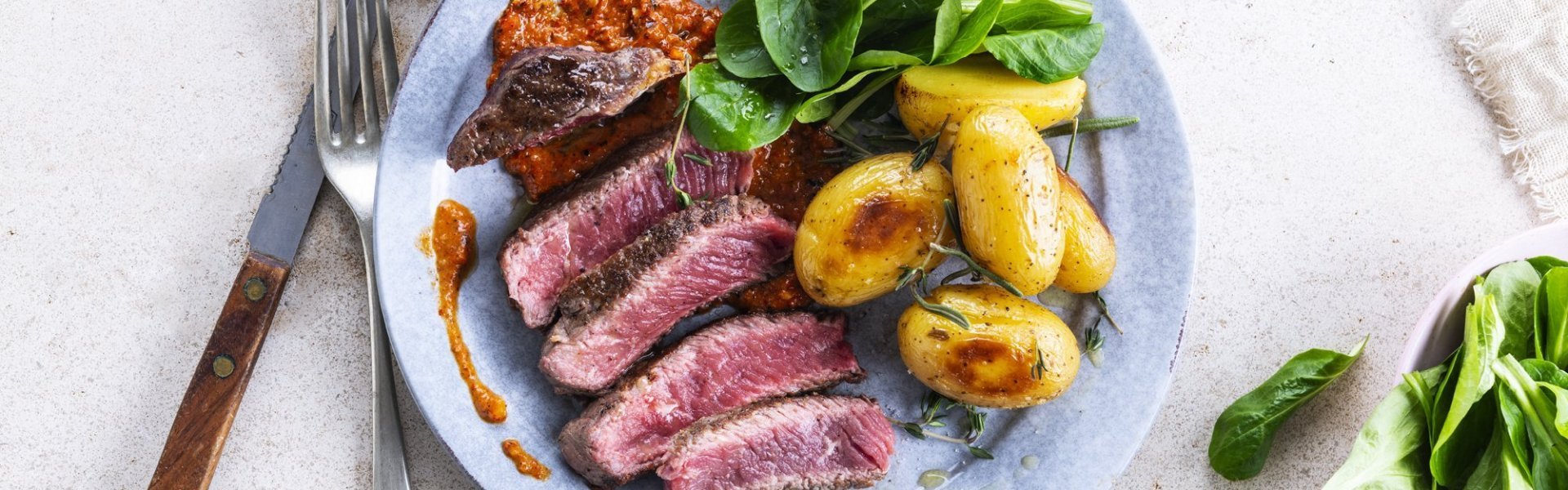 Gegrilde steak met romescosaus en gepofte krieltjes Gegrilde steak met romescosaus en gepofte krieltjes