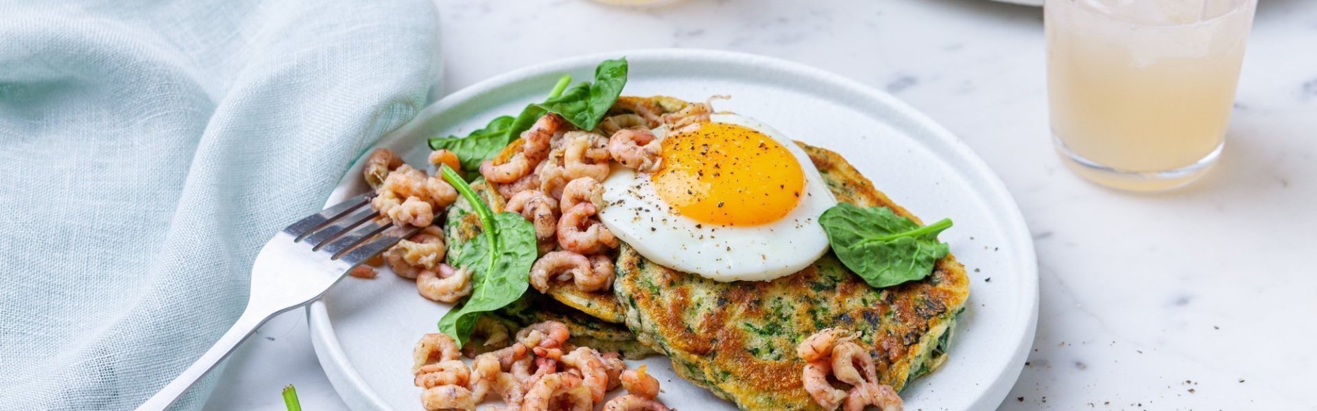 Hartige spinazie-courgettepannenkoekjes met een spiegelei en garnalen. Aangevuld met 2 glazen limonade.