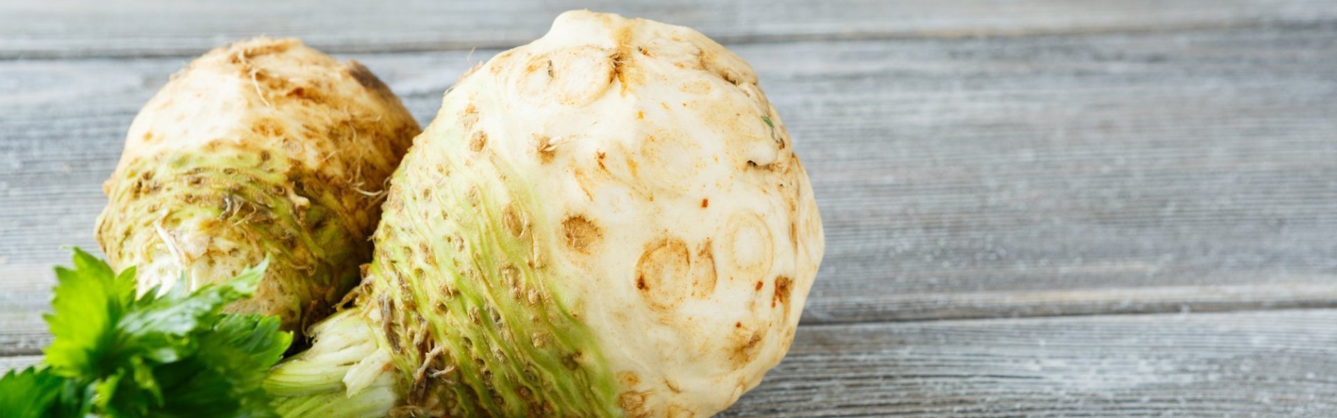 Knolselder Twee volledige knolselders liggen op houte grijze tafel.