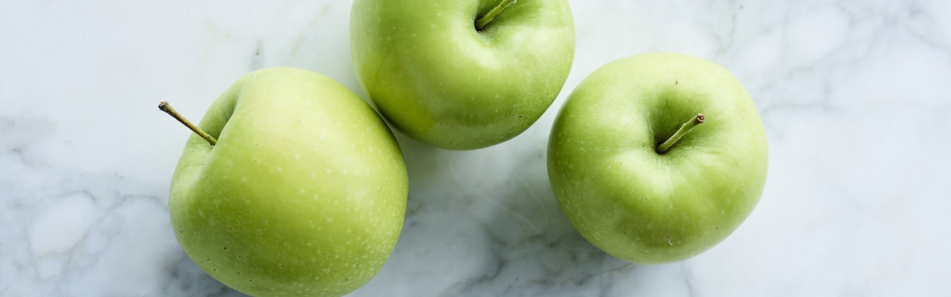 3 Golden-appels op marmeren keukenaanrecht.