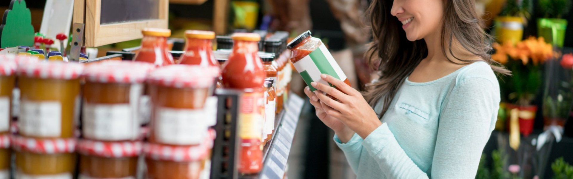 Vrouw kijkt naar bioproduct in biowinkel. 